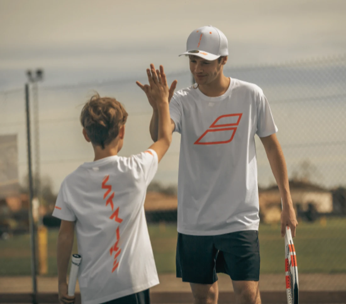 trainer en kind doen high five na een wedstrijdje